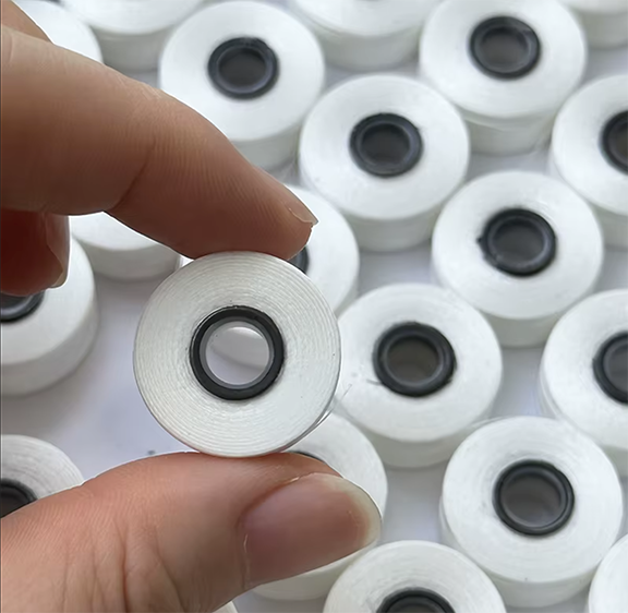Close view of a Stitchcraft magnetic core prewound embroidery bobbin
